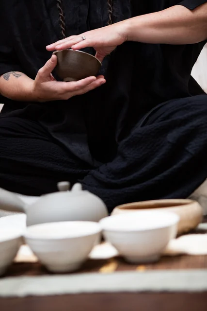 Hands holding a ceramic tea bowl