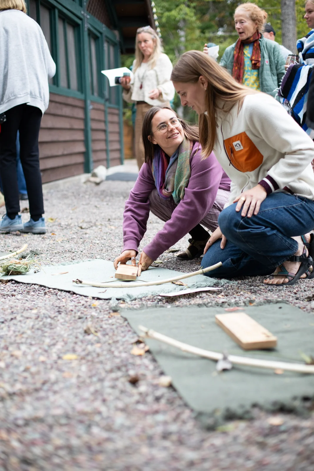 Guests learning a fire-making activity together outdoors