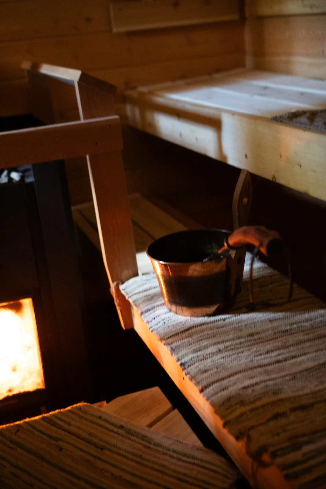 A wooden bucket and benches inside the sauna